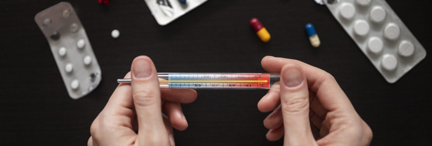 hands-holding-thermometer-close-up